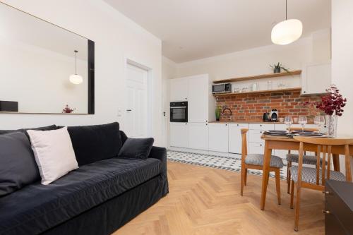 a living room with a couch and a table and a kitchen at Warsaw Pruszków Park View Comfortable Apartments by Noclegi Renters in Pruszków