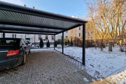 a car parked under a garage in the snow at Warsaw Pruszków Park View Comfortable Apartments by Noclegi Renters in Pruszków