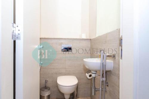 a bathroom with a toilet and a sink at Spectacular 2 Bedroom In Oasis in Al Qurayyah