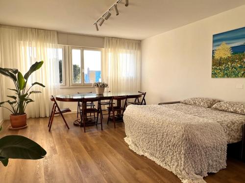 1 dormitorio con 1 cama y mesa de comedor en Padova - 35 min Venezia - Suite Picasso Deluxe, en Sarmeola