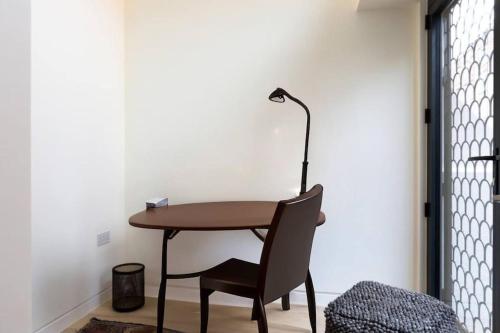 une table, une chaise et une lampe dans une pièce dans l'établissement Quiet and Peaceful House near Marble Arch, à Londres