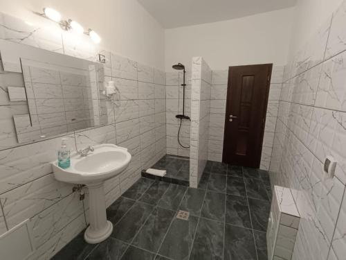 un bagno bianco con lavandino e doccia di Mozart Studios a Cluj-Napoca