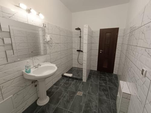 a white bathroom with a sink and a shower at Mozart Apartments in Cluj-Napoca