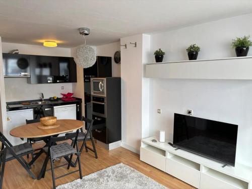 a kitchen and living room with a table and a television at Apartamento Astun in Astun 