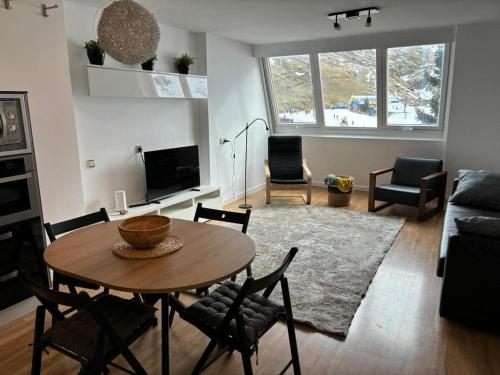 a living room with a wooden table and chairs at Apartamento Astun in Astún