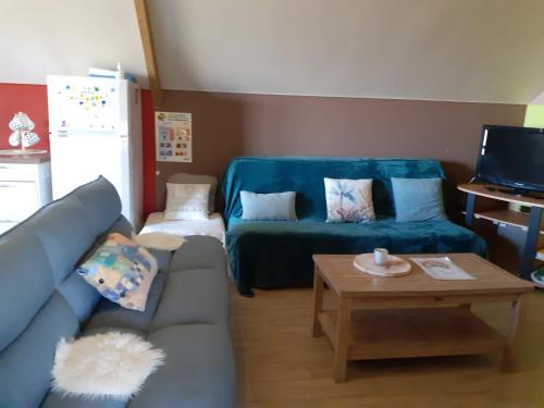 ein Wohnzimmer mit einem Sofa und einem Tisch in der Unterkunft A l'orée du Bois in Landelies