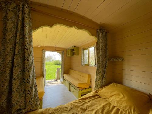 Habitación pequeña con 2 camas y ventana en Chambre d'hôtes de Paille et d'Argile, en Touligny
