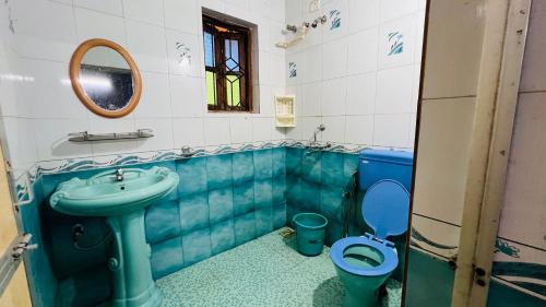 a bathroom with a blue sink and a toilet at HARSH ANGEL HOLIDAY HOMES in Calangute