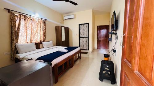 a bedroom with a bed and a television in it at HARSH ANGEL HOLIDAY HOMES in Calangute