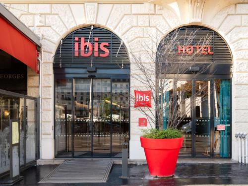 un grand pot rouge devant un magasin dans l'établissement ibis Lyon Centre Perrache, à Lyon