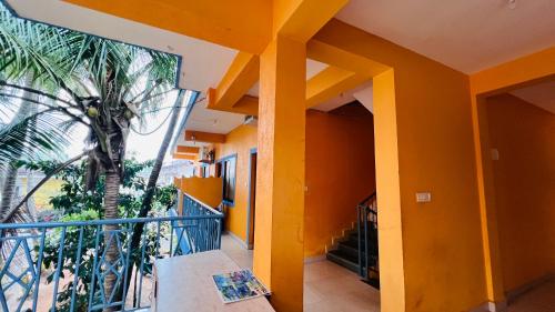 a house with orange walls and a balcony with a palm tree at Harsh angel holiday homes in Calangute