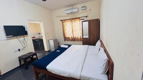 a bedroom with a bed and a television in it at Harsh angel holiday homes in Calangute