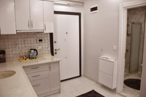 a kitchen with white cabinets and a white door at Kaya city rezidans in Nevsehir