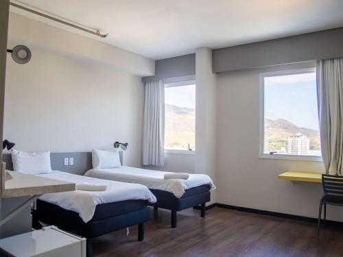 三河的住宿－ibis Styles Tres Rios，酒店客房设有两张床和窗户。