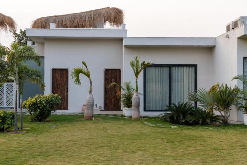 a white house with palm trees in front of it at LA VIDA RETREAT in Jaipur