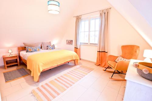 a bedroom with a bed and a chair and a window at Ferienhaus Muscheltaucher in Kramerhof
