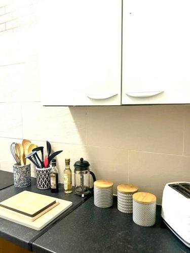 een aanrecht met een aanrecht met krukken en een fornuis bij Saxon Cottage St Leonards on sea in Hastings