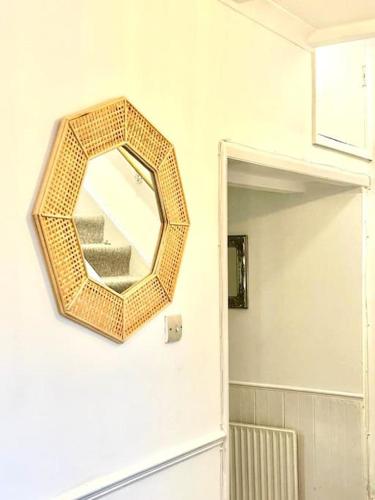 a mirror hanging on a wall in a bathroom at Saxon Cottage St Leonards on sea in Hastings