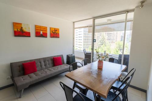ein Esszimmer mit einem Tisch und einem Sofa in der Unterkunft Kennedy Apartments Los Militares in Santiago