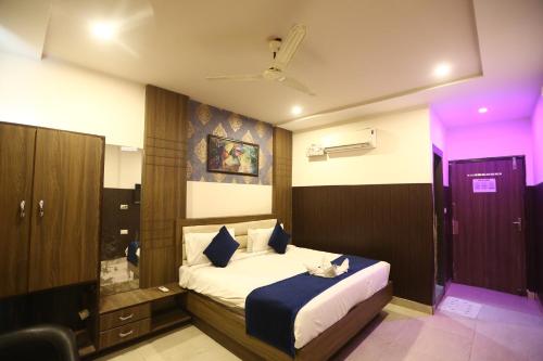 ein Schlafzimmer mit einem Bett und einer violetten Beleuchtung in der Unterkunft Hotel Orchid & Banquet in Agra