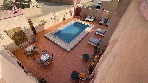 an overhead view of a swimming pool with tables and chairs at Riad Dar Poublanc in Merzouga