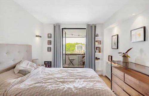 ein weißes Schlafzimmer mit einem großen Bett und einer Kommode in der Unterkunft US embassy spacious apartment nine elms in London
