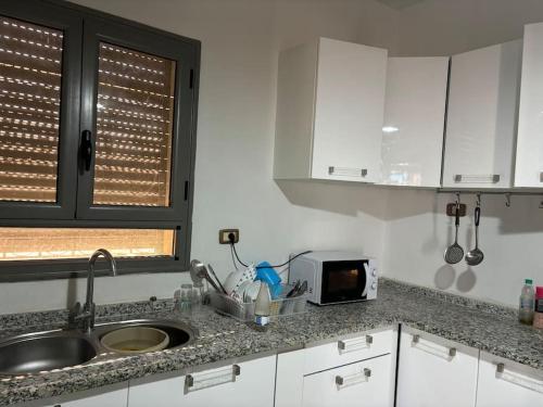 a kitchen counter with a sink and a microwave at Villa luxe calme djerba in Midoun