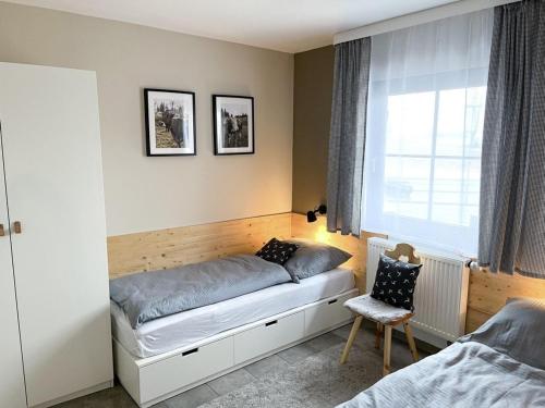 a bedroom with a bed and a window at Ferienhaus Nr 47, Kategorie Premium, Feriendorf Hochbergle, Allgäu in Bichel