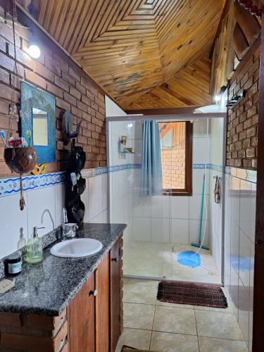 a bathroom with a sink and a shower at Casa das nuvens in Itatiaia