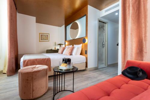 a hotel room with two beds and a couch at Hotel Sacha in Paris
