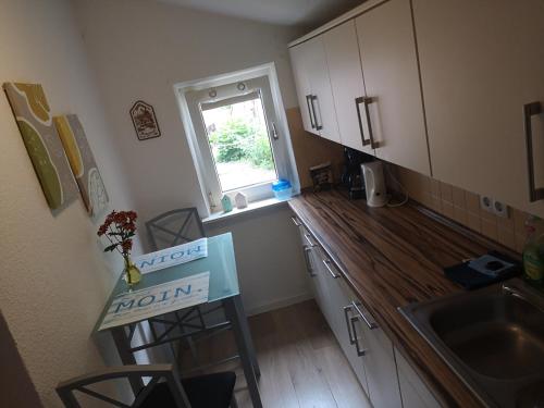a kitchen with a sink and a wooden counter top at Ferienwohnung Ostfriesland in Stapelmoor