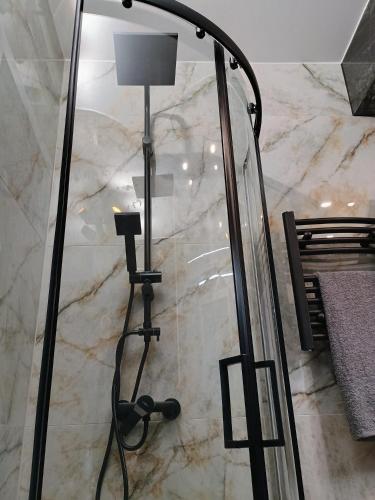a floor lamp in a room with a marble wall at Apartament EM in Krosno