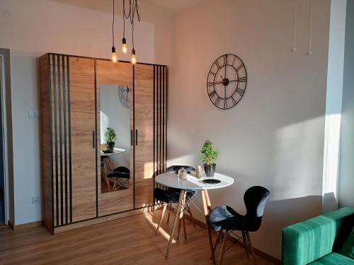 a dining room with a table and a mirror at Apartament EM in Krosno