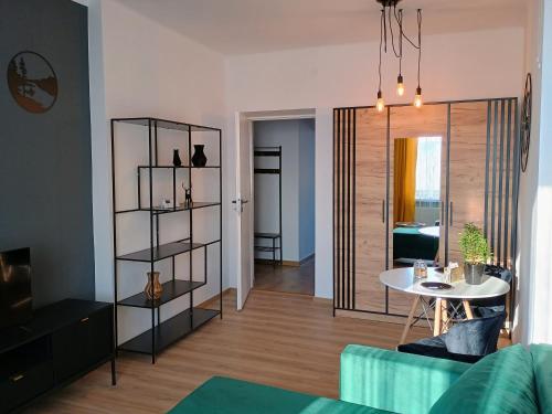 a living room with a table and a dining room at Apartament EM in Krosno