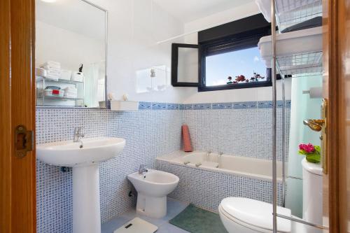 a bathroom with a sink and a toilet and a tub at Amadeus in La Oliva