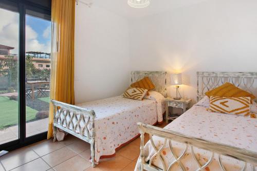 a bedroom with two beds and a balcony at Amadeus in La Oliva