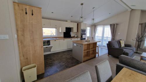 a kitchen and living room with a couch and a table at Camber Sands Holiday Park in Camber