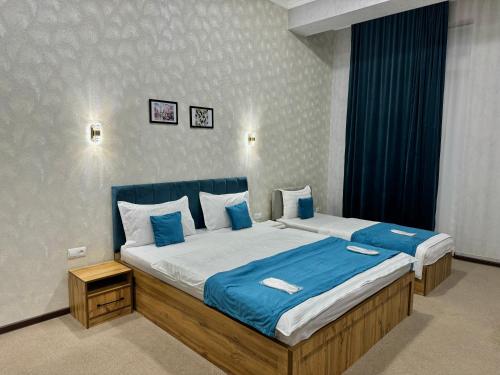 タシュケントにあるResident Hotelのベッドルーム1室(大型ベッド1台、青いシーツ付)