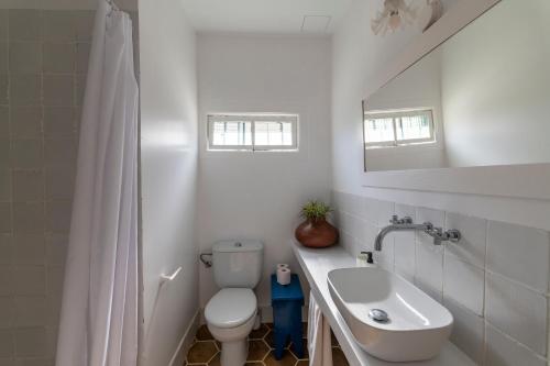 a white bathroom with a toilet and a sink at Finca San Diego with Pool & Wifi in La Matanza de Acentejo