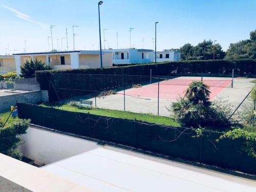 um campo de ténis com uma cerca e um campo de ténis em Villetta Bianca em Torre dell'Orso