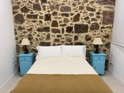 a bedroom with a bed with two blue night stands at Casa Ma in Guatiza