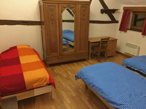 una camera da letto con cassettiera, letto e specchio di Rustic renovated farmhouse with a private outdoor sauna in the garden a Somme-Leuze