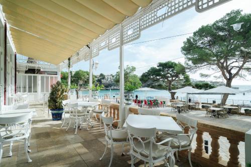 a restaurant with tables and chairs and a view of the water at THB Felip - Adults Only in Porto Cristo