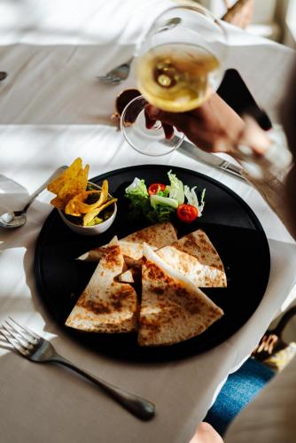 a table with a plate of food and a glass of wine at THB Felip - Adults Only in Porto Cristo