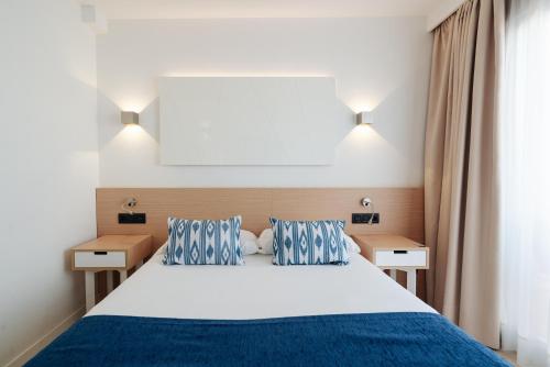 a bedroom with a large bed with blue and white at THB Felip - Adults Only in Porto Cristo
