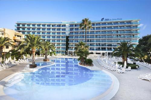 uma grande piscina com cadeiras e um hotel em THB Sa Coma Platja em Sa Coma