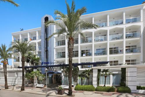 un hotel con palmeras delante en THB Gran Playa - Adults Only, en Can Picafort