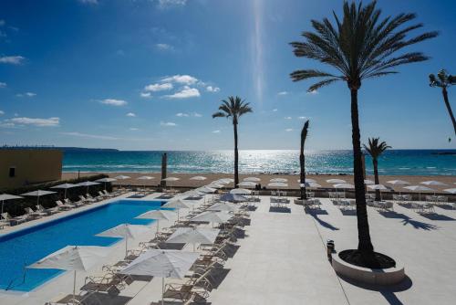 een resort met een zwembad en palmbomen en de oceaan bij THB El Cid - Adults Only in Can Pastilla