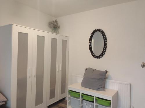 a bedroom with a cabinet and a pillow and a mirror at Easy Stay in Streatham