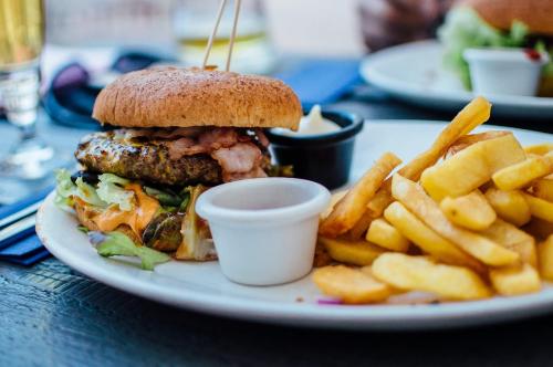 a plate with a sandwich and french fries on a table at Happy happy home saket in New Delhi